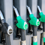 High-resolution image of diesel and petrol fuel pump nozzles at a gas station during rising global oil price concerns.