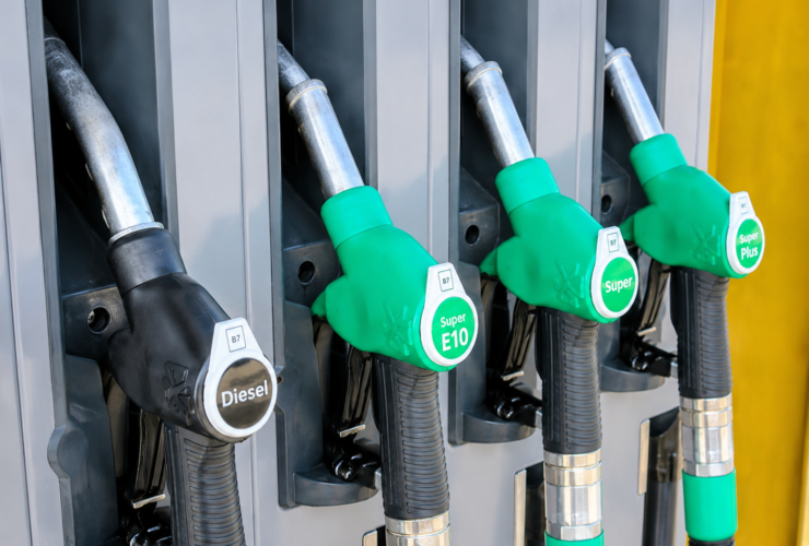 High-resolution image of diesel and petrol fuel pump nozzles at a gas station during rising global oil price concerns.