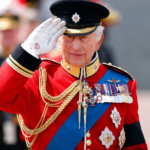 King Charles III salutes during a ceremonial event after revealing his tax bill in the annual Royal Household financial report.