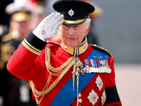 King Charles III salutes during a ceremonial event after revealing his tax bill in the annual Royal Household financial report.