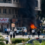 Emergency responders gather after Damascus bomb explosions near the Four Seasons Hotel during Emmanuel Macron's visit to Syria.